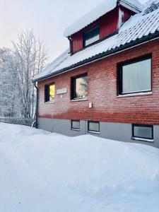 a red brick house with snow in front of it at Annie Järdebergsgatan 3 in Kiruna