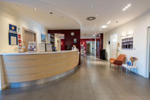 a lobby of a pharmacy with a counter and chairs at Best Western Palace Inn Hotel in Ferrara