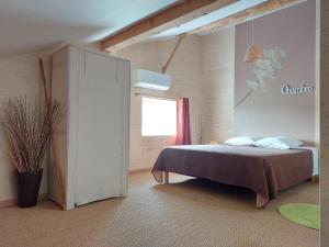 a bedroom with a bed and a window at Le Clos de Saint Amour in Montauban