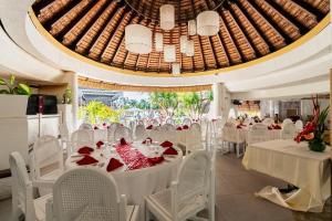 a banquet hall with white tables and white chairs at Casuarina Resort and Spa in Trou aux Biches