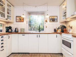 a kitchen with white cabinets and a window at 4 person holiday home in Vejby in Vejby