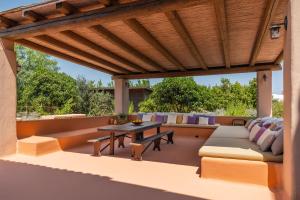 an outdoor patio with a wooden pergola at Masseria De Li Travaj - Rive del Salento in Patù