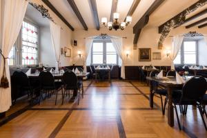 a dining room with tables and chairs and windows at Eventlocation & Hotel Schloss Neuburg in Obrigheim