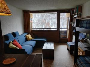 a living room with a blue couch and a window at Studio Le Fontagnel in Molines-en-Queyras +9 photos