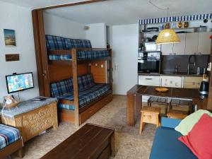 a living room with a bunk bed and a desk at Studio Le Fontagnel in Molines-en-Queyras