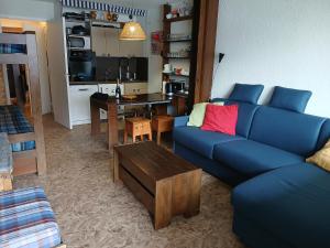 a living room with a blue couch and a table at Studio Le Fontagnel in Molines-en-Queyras