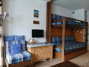 a bedroom with a bunk bed and a chair at Studio Le Fontagnel in Molines-en-Queyras