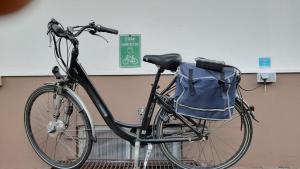a bike parked next to a building with a blue bag on it at Café-Pension Krems in Waischenfeld