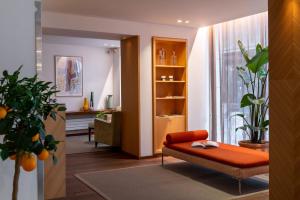 ein Wohnzimmer mit einer orangefarbenen Couch und einem Fenster in der Unterkunft Hôtel Le Colisée in Paris