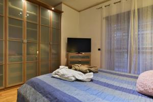 1 dormitorio con 1 cama y TV. en Home Sorbara "Luxury Home", en Roma