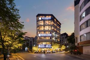 a tall building on a city street at night at 3A Hometel Hanoi in Hanoi