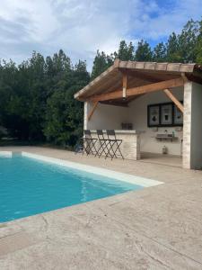 a pavilion with chairs and a swimming pool at Mas Tareau Chambres d Hotes in Beaucaire