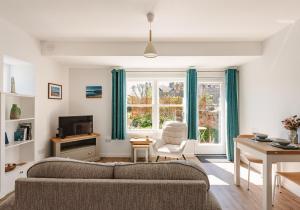 a living room with a couch and a window at Lochburn Cottage in Elie