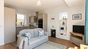a living room with a couch and a tv at Lochburn Cottage in Elie +20 photos