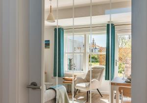 a room with a table and chairs and a window at Lochburn Cottage in Elie
