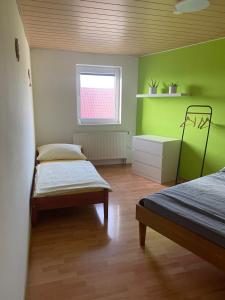 a bedroom with two beds and a green wall at Rekreační dům Strachotín in Strachotín