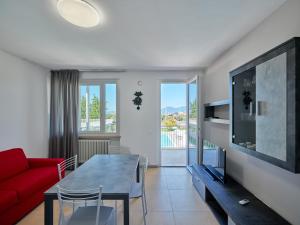 a living room with a red couch and a table at Residence Green Park in Torri del Benaco