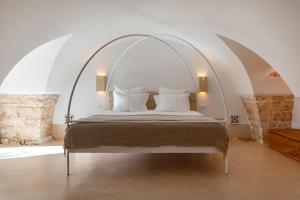 a bedroom with a bed with an arched ceiling at Masseria Valentina in Ostuni +73 photos