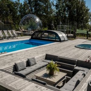 a swimming pool with a bench and a glass dome at Longbeach Life in Falkenberg +16 photos