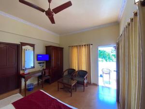 a living room with a bed and a desk and a television at Sealine Beach Resorts in Cherai Beach