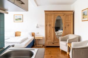 a bathroom with a bed and a sink in a room at Gutshaus Barkow in Barkhagen