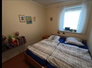 a bedroom with a bed and a window at Kinderparadies Norddeich in Norddeich