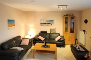a living room with a couch and a coffee table at Kinderparadies Norddeich in Norddeich
