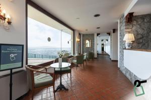 a room with a table and chairs and a large window at Hotiday Taormina Baia in Taormina