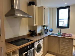 a kitchen with a washer and a sink and a stove at Sunderland City Cozy Flat in Sunderland