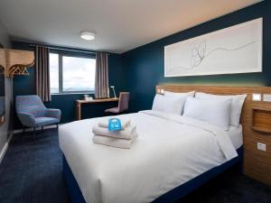 a hotel room with a bed with towels on it at Travelodge Egham in Egham