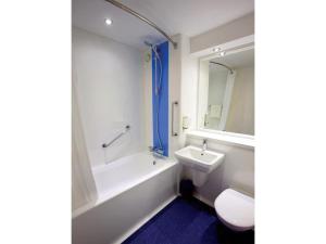 a bathroom with a sink and a tub and a toilet at Travelodge Widnes in Widnes