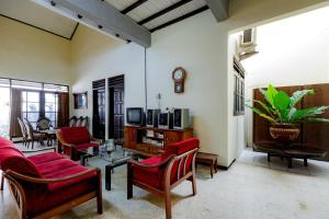 a living room with red chairs and a tv at RedDoorz @ Soekarno Hatta 2 in Malang