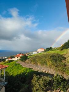 a rainbow in the sky over a hill at Golden Sun Refugio -Calheta in Estreito da Calheta