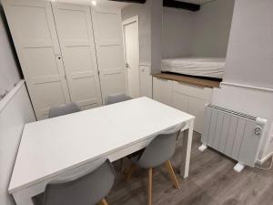 a room with a white table and chairs and a bed at Loft 4 personas en La Molina in La Molina