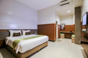 a bedroom with a large bed and a bathroom at Akasia Budget Hotel in Ulujami +32 photos