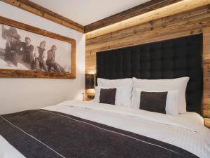 a bedroom with a large bed with a black headboard at VAYA Sölden in Sölden