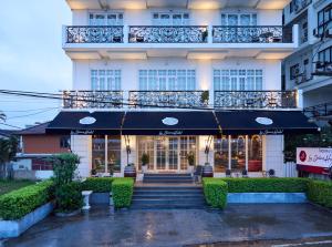 a building with a black umbrella in front of it at La Seine Boutique Hotel in Vientiane