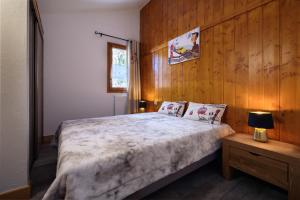 a bedroom with a bed with a wooden wall at Alpes Roc in Pralognan-la-Vanoise
