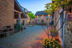 a cobblestone street in a courtyard with buildings at Auberge de Smockelaer in Heijenrath