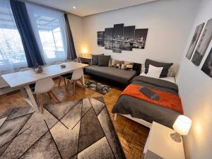 a room with two beds and a table and a couch at Großes Apartment Aschaffenburg 4 Schlafzimmer bis zu 10 Personen Mainpark Apartment Mainaschaff in Mainaschaff