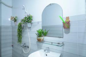 a bathroom with a sink and a mirror and plants at Nhà Nghỉ Hiếu Thuận in Nhơn Trạch +23 photos