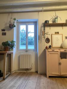 a kitchen with a window and a wooden floor at Joli maison de bourg in Savennières