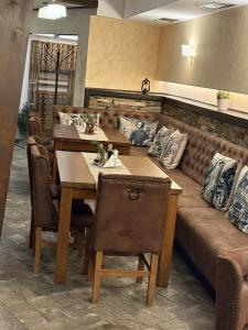 a dining room with a couch and a table and chairs at Hotel Smilen in Smolyan
