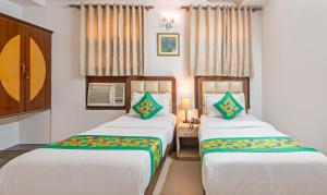 two beds in a hotel room withskirts at Hotel Paras in New Delhi