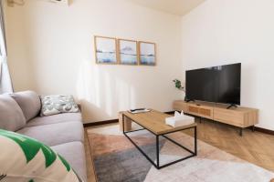 a living room with a couch and a flat screen tv at Fuji Life House in Fuji