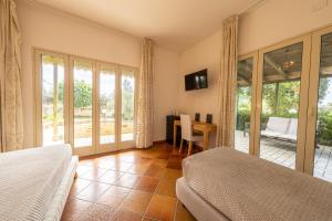 a bedroom with two beds and a table with a chair at Villa Carlotta Resort in San Leone