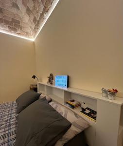 a bedroom with a bed and a shelf on the wall at La casa del tempo in Vittorito
