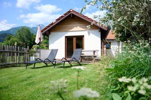 a house with two chairs and an umbrella in a yard at Amsel Haus in Bayrischzell
