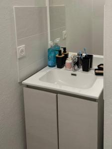 a bathroom counter with a sink and a mirror at Le Cocoon Elite in Beynost