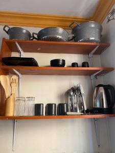 a kitchen shelf with pots and pans and utensils at Bliss Residence Studio Mtwapa in Mtwapa +4 photos